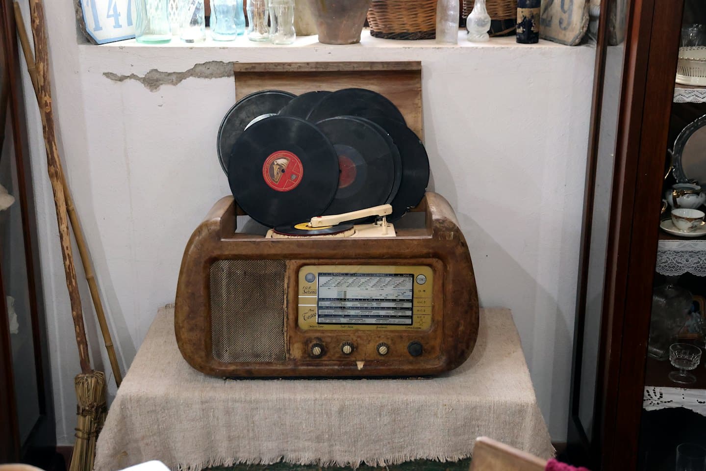 Giradischi vintage con dischi in vinile su una tovaglia di lino.
