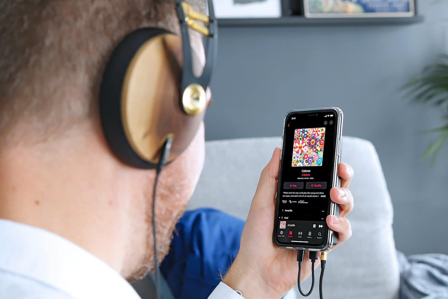 Persona con cuffie che usa un'app musicale sullo smartphone.